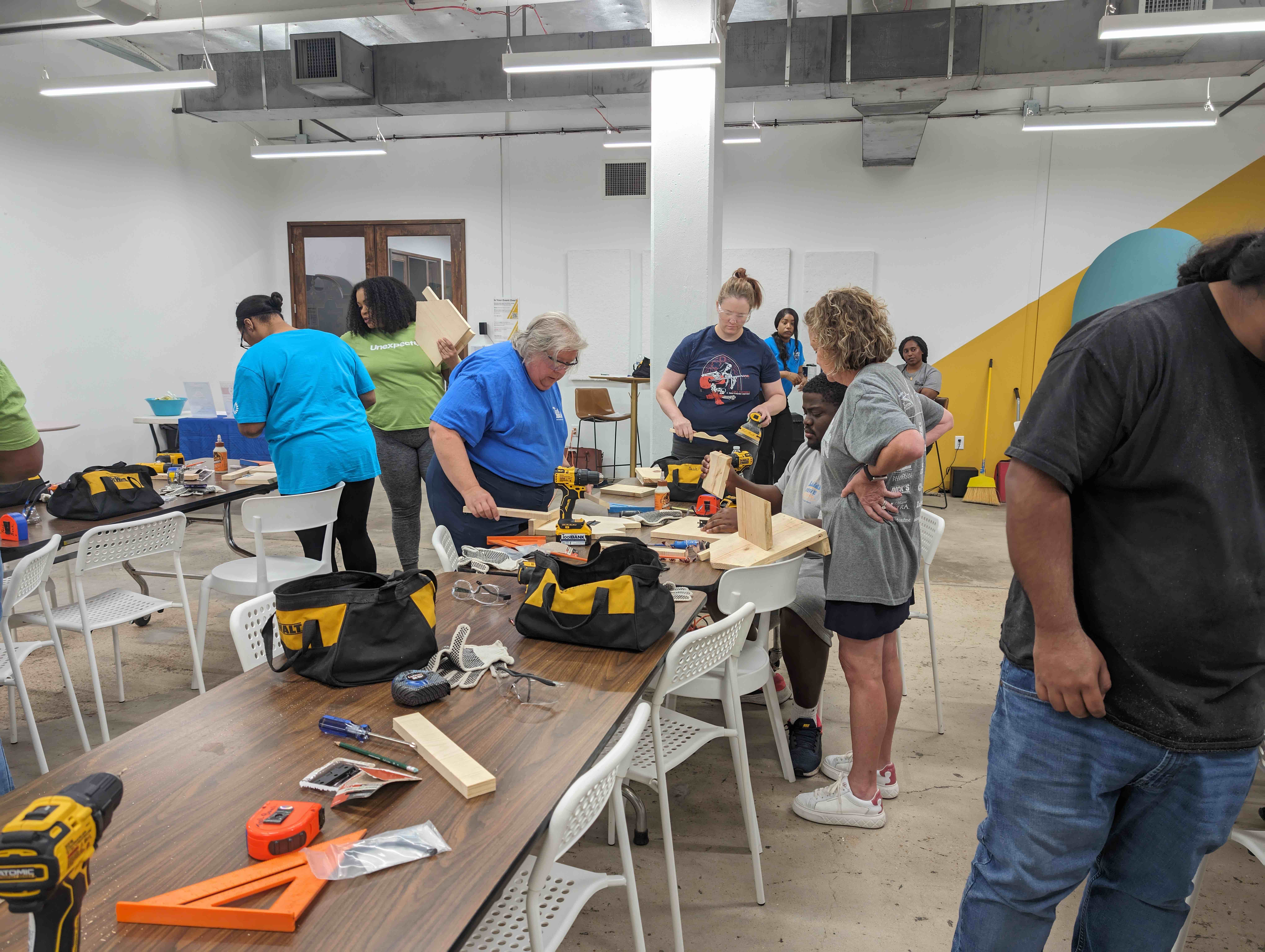 Houston ToolBank volunteers showing students how to use tools in the Tool School